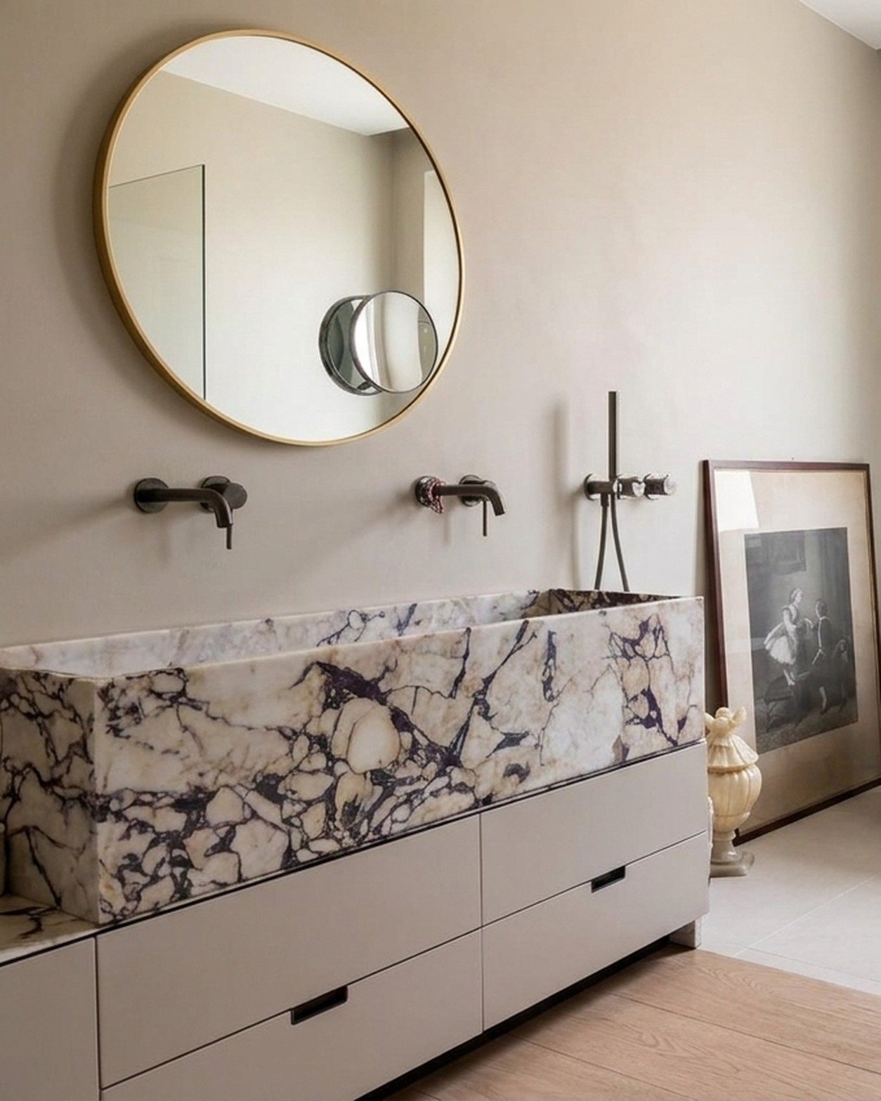 Lavabo doppio monolitico in marmo a vene viola con specchio tondo in ottone e rubinetteria a parete brunita